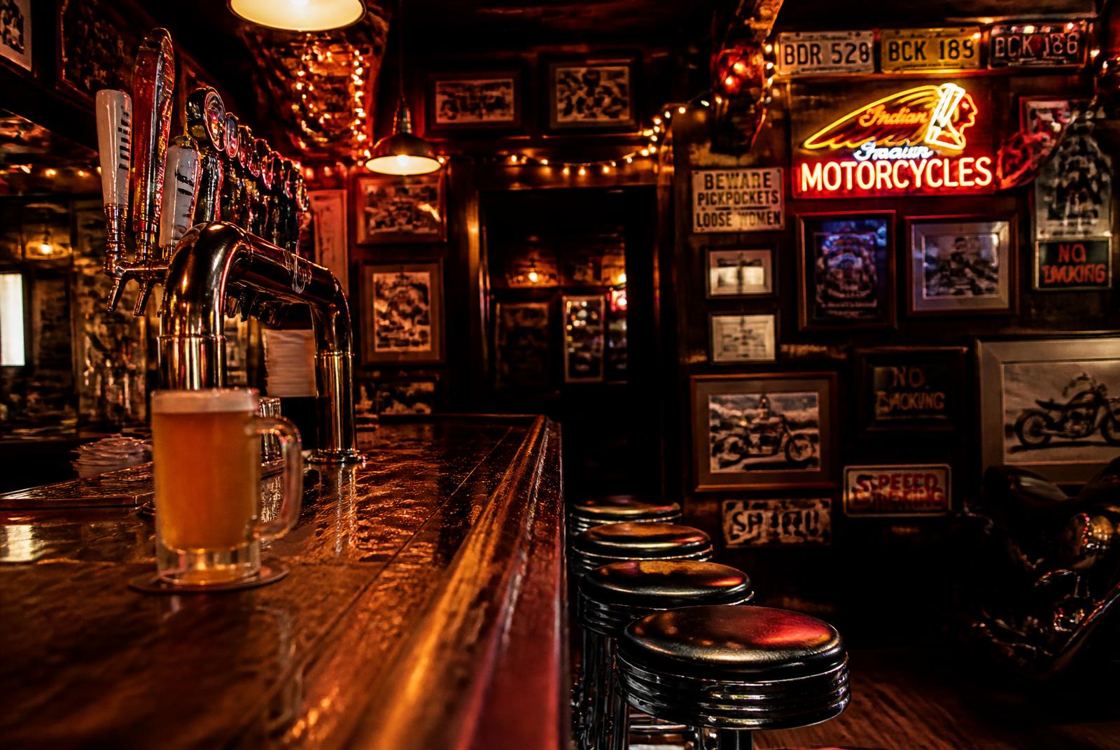 Chrome beer taps and a frosty mug on the polished wood bar